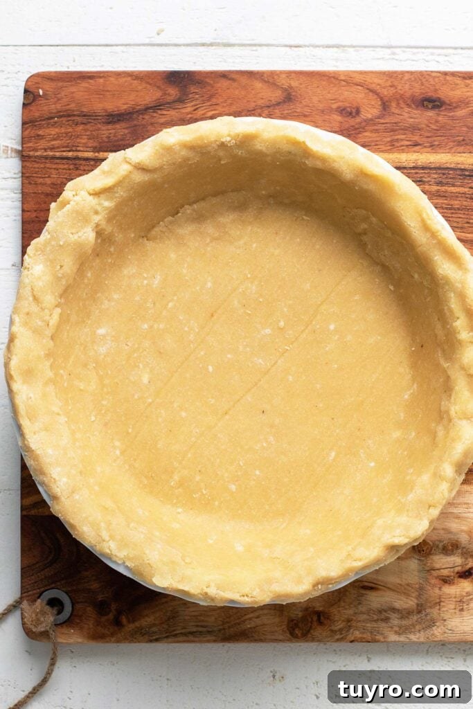 Flaky Almond Flour Pie Crust Recipe for Perfect Pastries 2 An almond flour pie crust shown pressed into a pie plate.