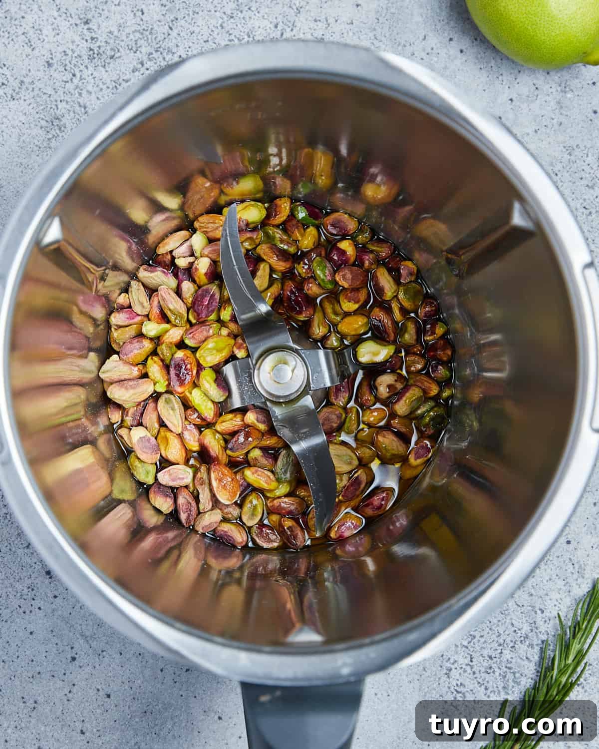 Vegan Whipped Feta Dip with Pistachios Lime Leaves and Rosemary 4 Overhead photo showing pistachios and olive oil in the food processor.