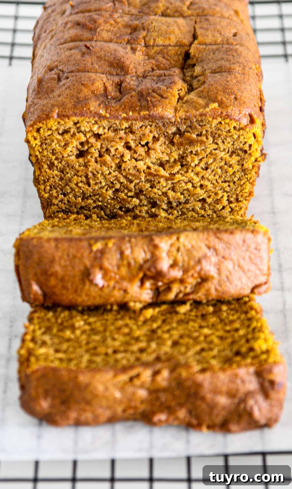 Gluten Free Pumpkin Bread Recipe 2 A gluten free pumpkin loaf with two slices cut from it.