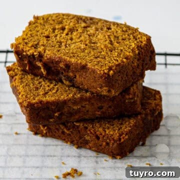 Gluten Free Pumpkin Bread Recipe 9 Three slices of gluten free pumpkin loaf stacked on a plate.