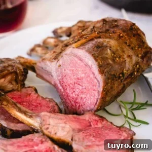 Sliced roasted rack of lamb on a white platter.