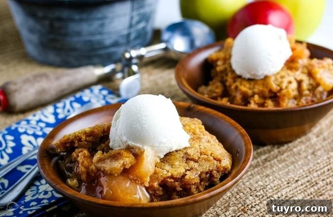 Slow Cooker Apple Dump Cake Recipe for Fall Desserts 8 2 wooden bowls filled with apple dump cake and a scoop of vanilla ice cream