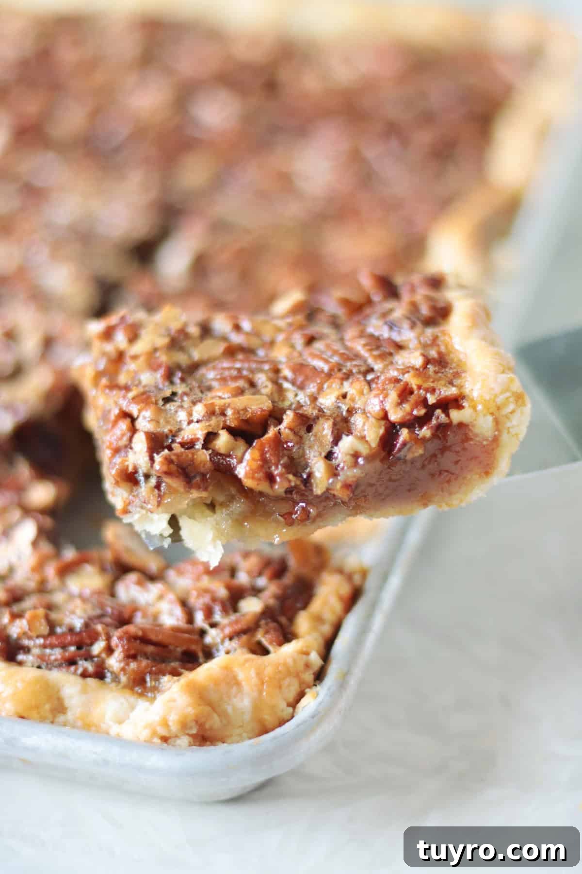 Sheet Pan Pecan Slab Pie Recipe 2 Slice of pecan slab pie on spatula.