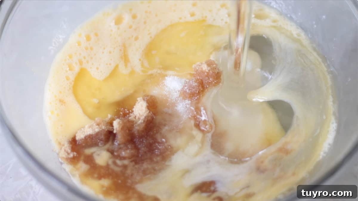Sheet Pan Pecan Slab Pie Recipe 7 Glass mixing bowl with eggs, corn syrup, sugar, salt.