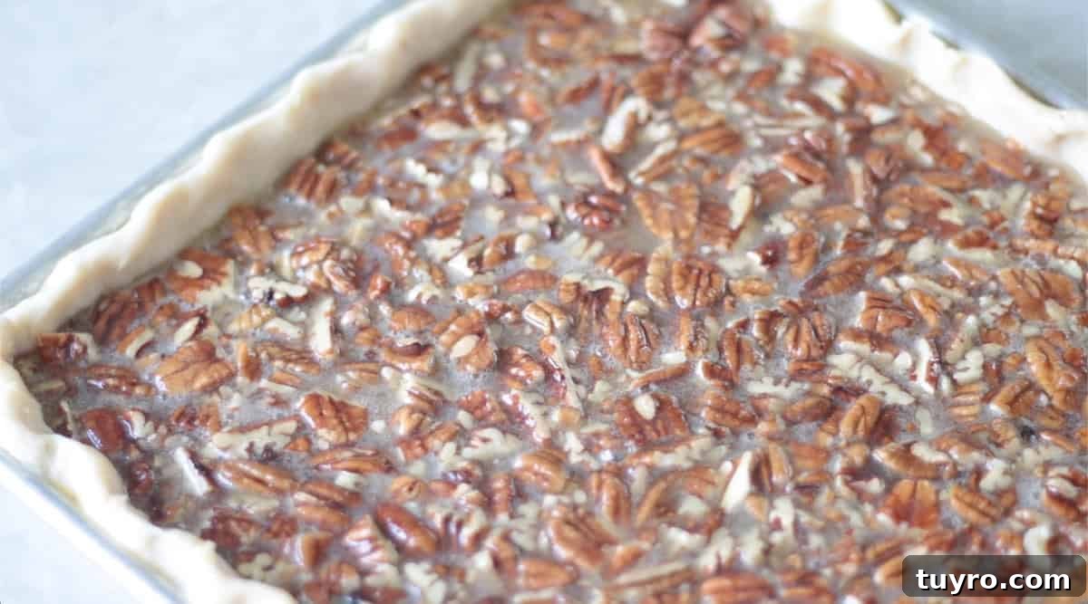 Sheet Pan Pecan Slab Pie Recipe 9 Unbaked pecan slab pie in jelly roll pan.