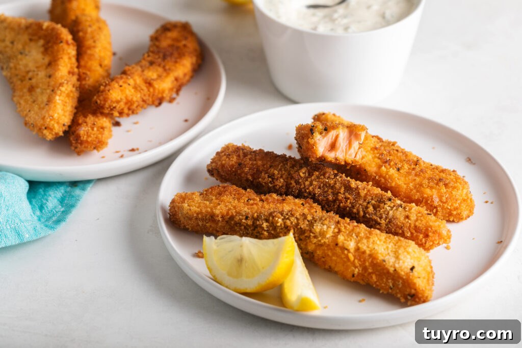 plate of salmon fish sticks with lemon wedges