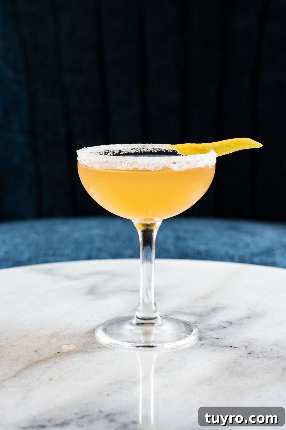 Classic Sidecar Cocktail Recipe: How to Mix the Perfect Brandy Sour 2 Sidecar cocktail garnished with a sugar rim and lemon peel.