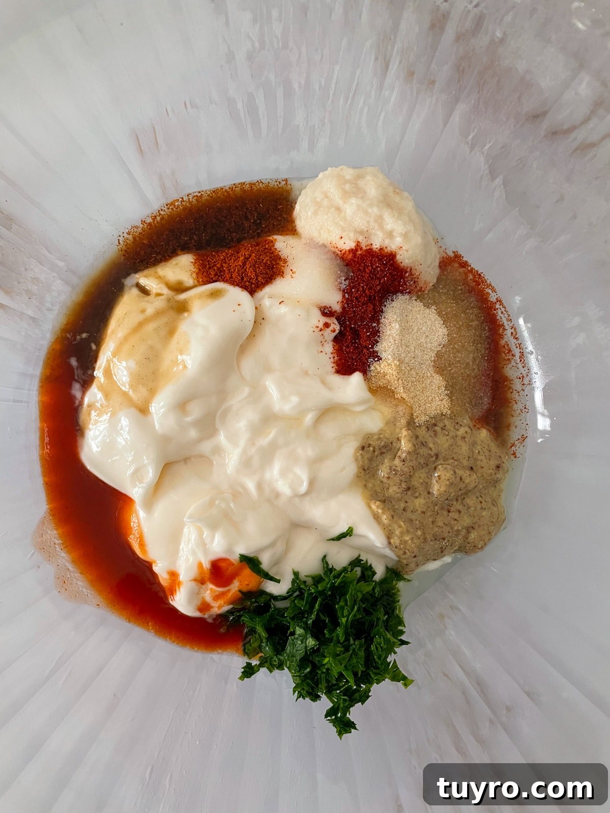 New Orleans remoulade sauce ingredients in glass bowl.
