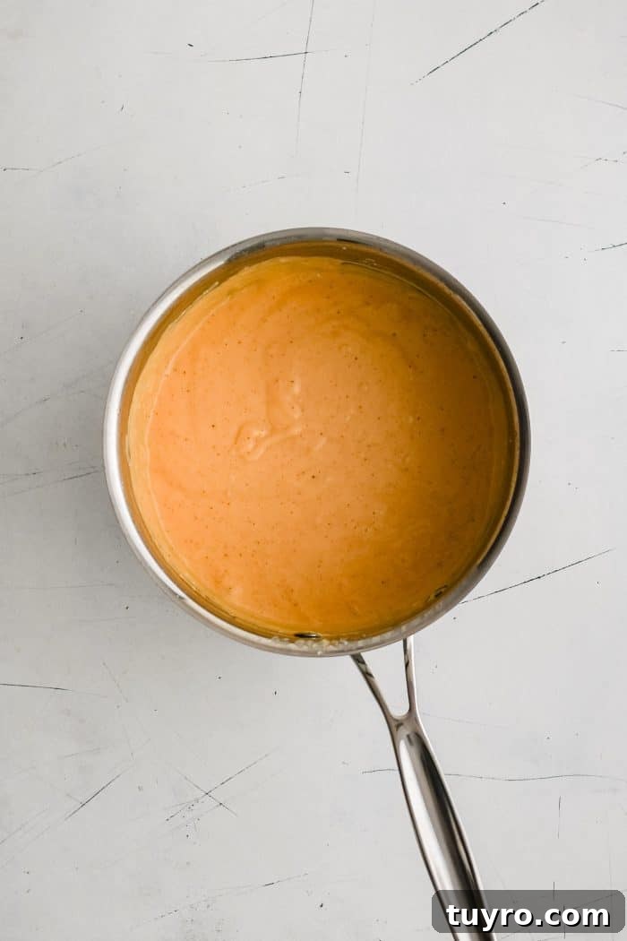 A small pot filled with homemade nacho cheese sauce.