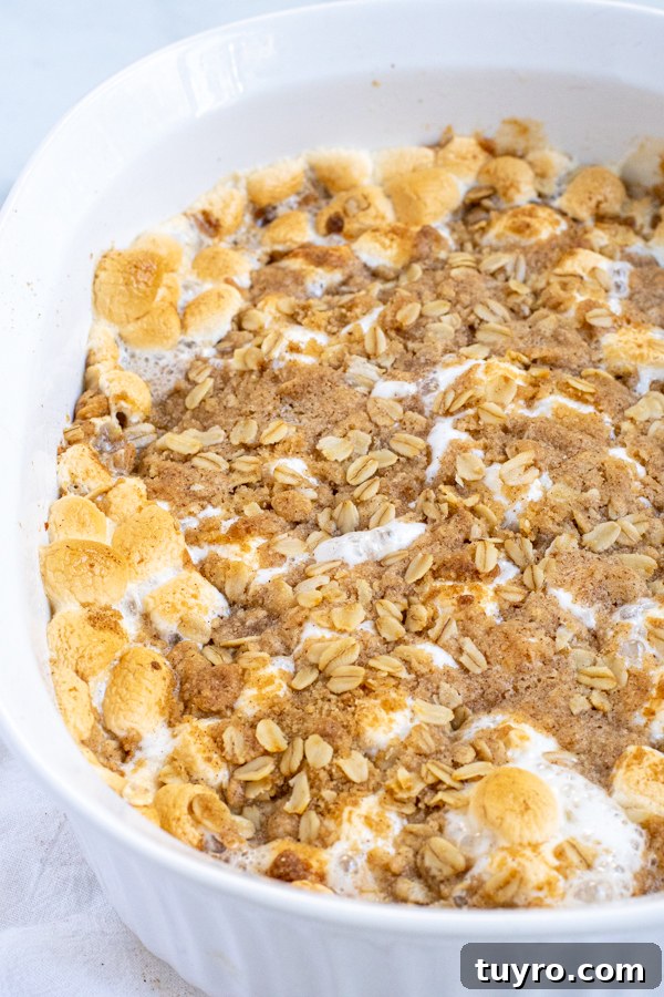 Sweet Potato Casserole with Marshmallows and Oat Streusel in a white casserole dish with brown marshmallows.