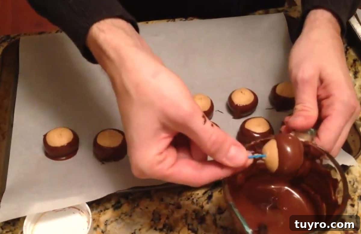 Nutella Buckeyes: Creamy Chocolate Hazelnut Truffle Recipe 3 Dipping peanut butter balls into melted chocolate to make buckeyes.