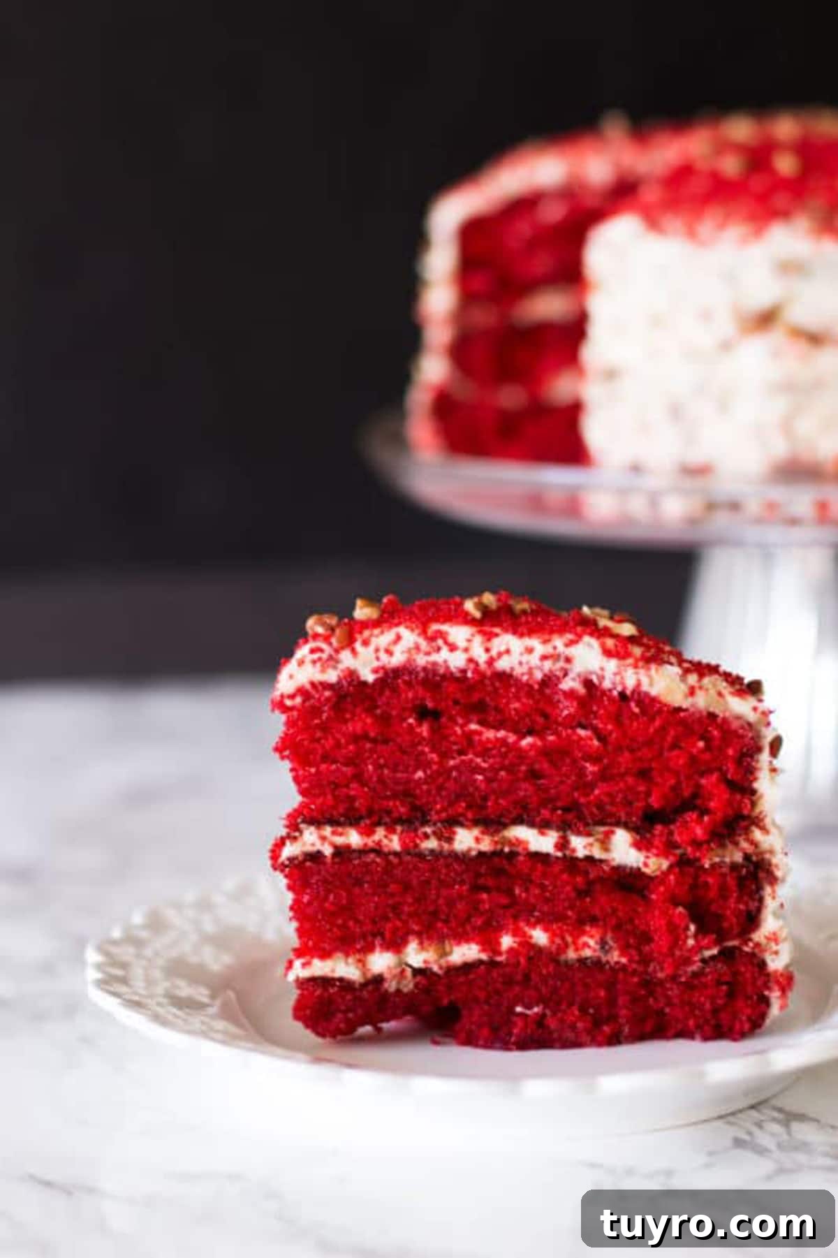 Classic Red Velvet Cake with Cream Cheese Frosting 19 Piece of a 3 layered Red Velvet Cake sitting on a white lace plate, sliced Red Velvet Cake sitting on a glass cake dish.