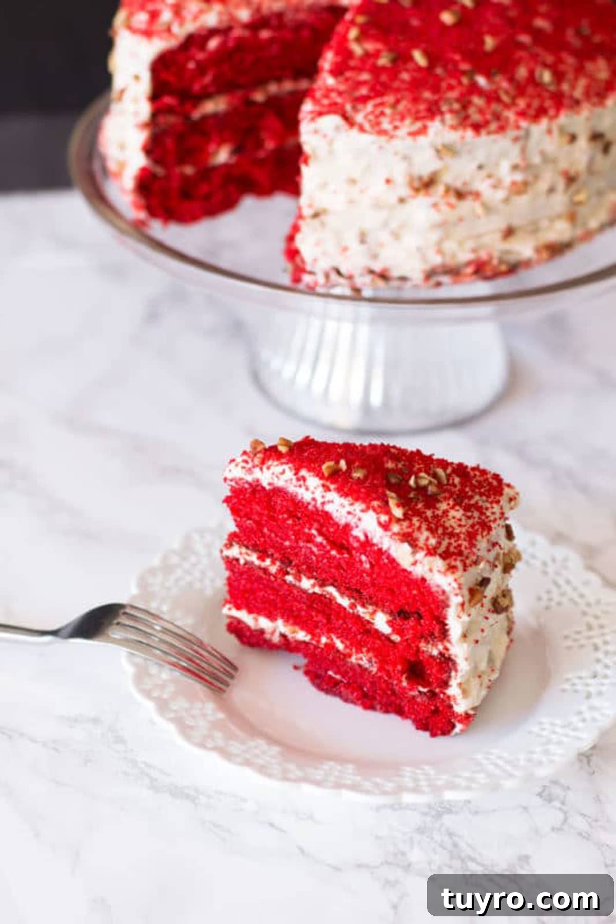 Classic Red Velvet Cake with Cream Cheese Frosting 4 Slice of Red Velvet Cake on a white lace plate, fork on side of plate. Red Velvet Cake on glass dish.