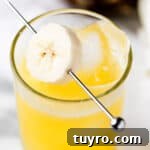 A banana rum cocktail garnished with banana slices.