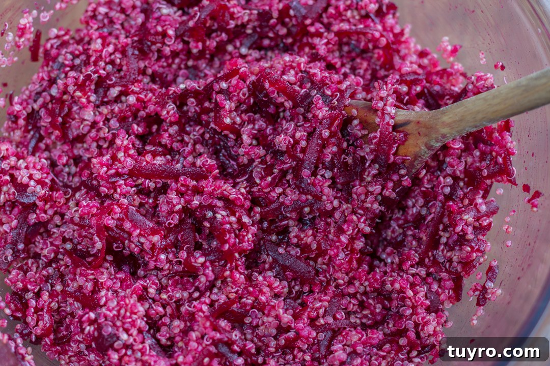 Steamed beets grated into warm cooked quinoa for a Buddha bowl base