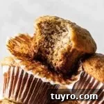 Banana muffins stacked on table with a close up of one muffin missing a bite