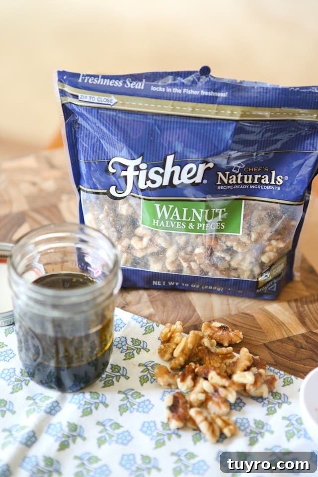 Spring Beet and Goat Cheese Salad with Walnuts package of Fisher walnut halves and pieces on a cutting board alongside dressing in a mason jar and a handful of the walnuts