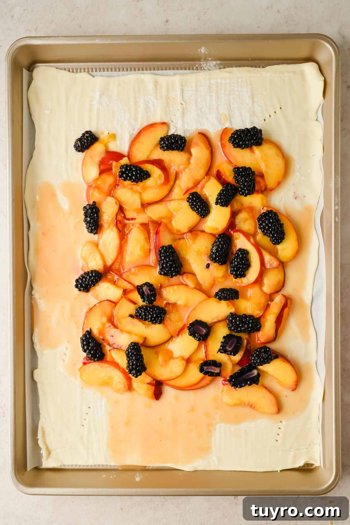 Rustic Peach and Berry Galette Recipe 6 rolled out puff pastry with peach and blackberry mixture on top.