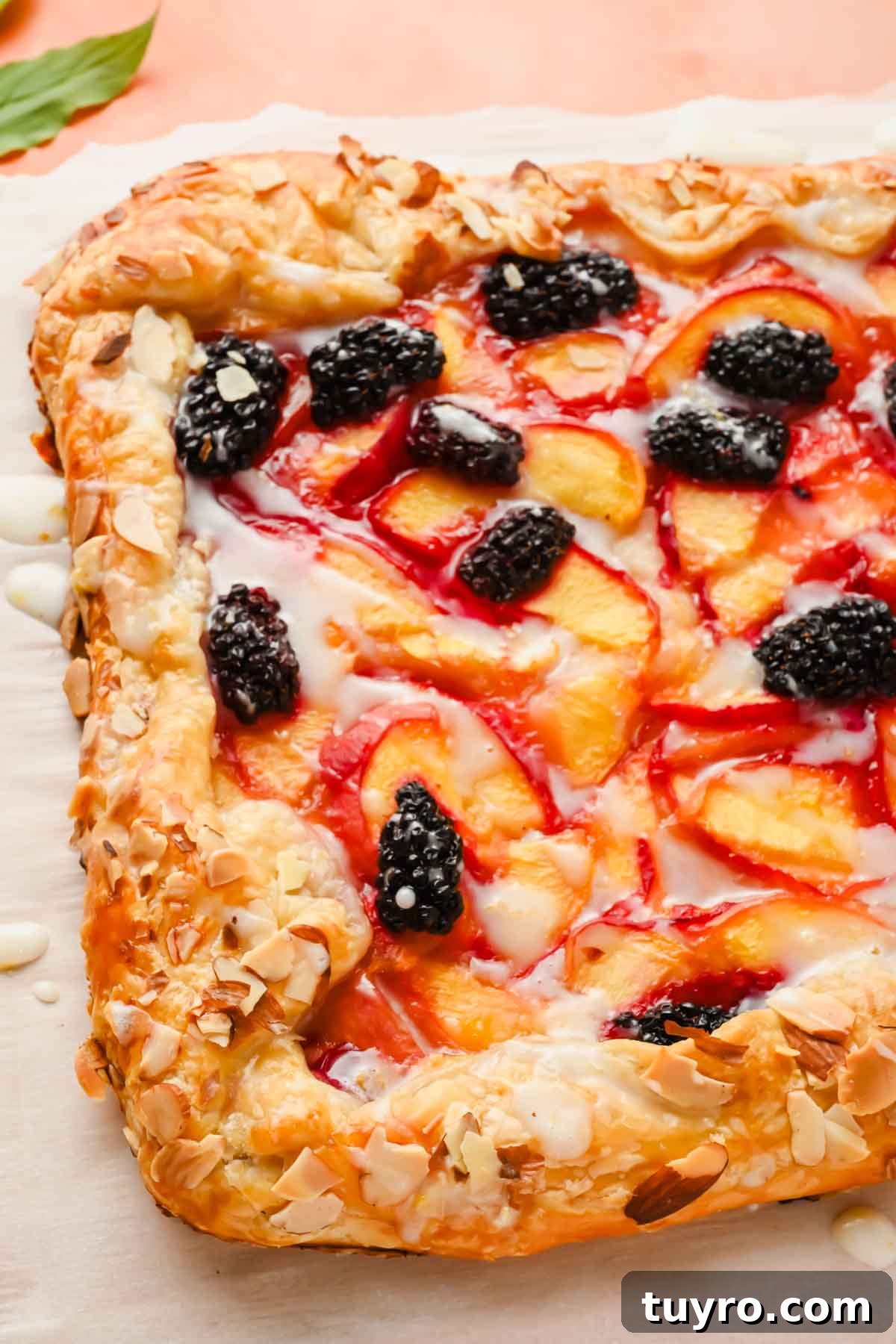 Rustic Peach and Berry Galette Recipe 8 baked puff pastry peach galette on clean parchment paper and wood cutting board.